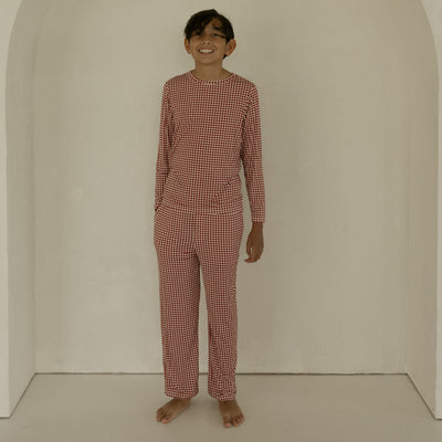 Person wearing a red checkered outfit standing in front of an archway.