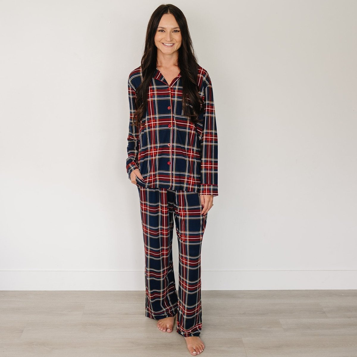 Woman wearing a plaid pajama set against a plain background