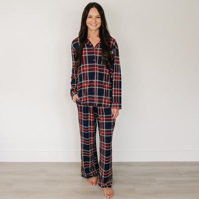 Woman wearing a plaid pajama set against a plain background