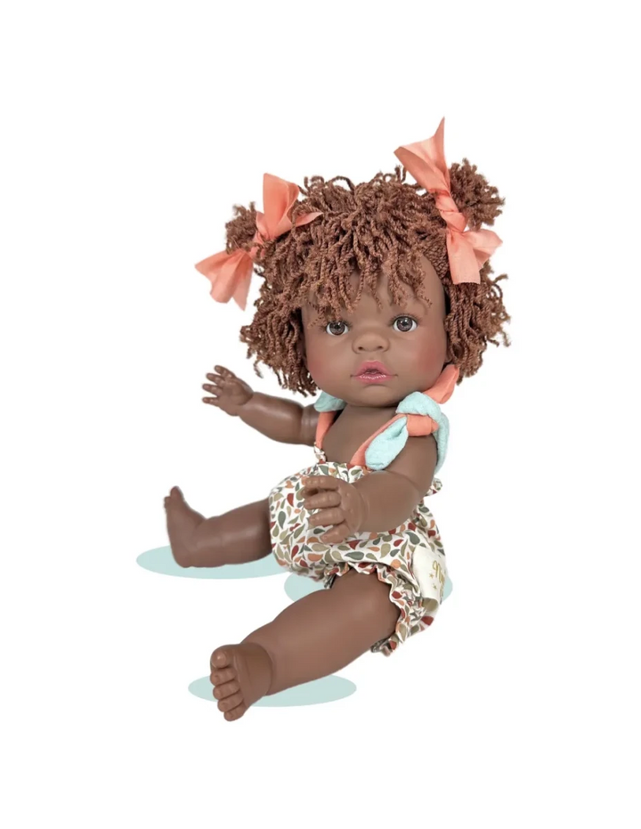 Doll with curly hair and floral outfit on a white background