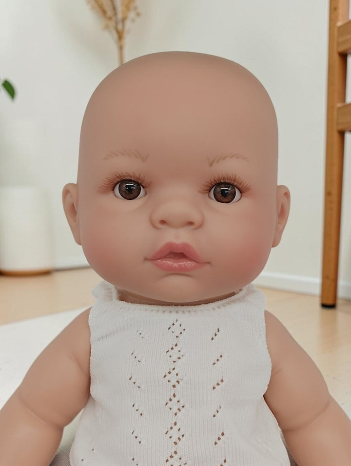 Baby wearing a white lace outfit indoors