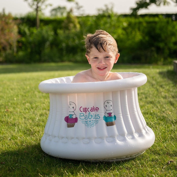 Child in a portable bathtub outdoors on a sunny day