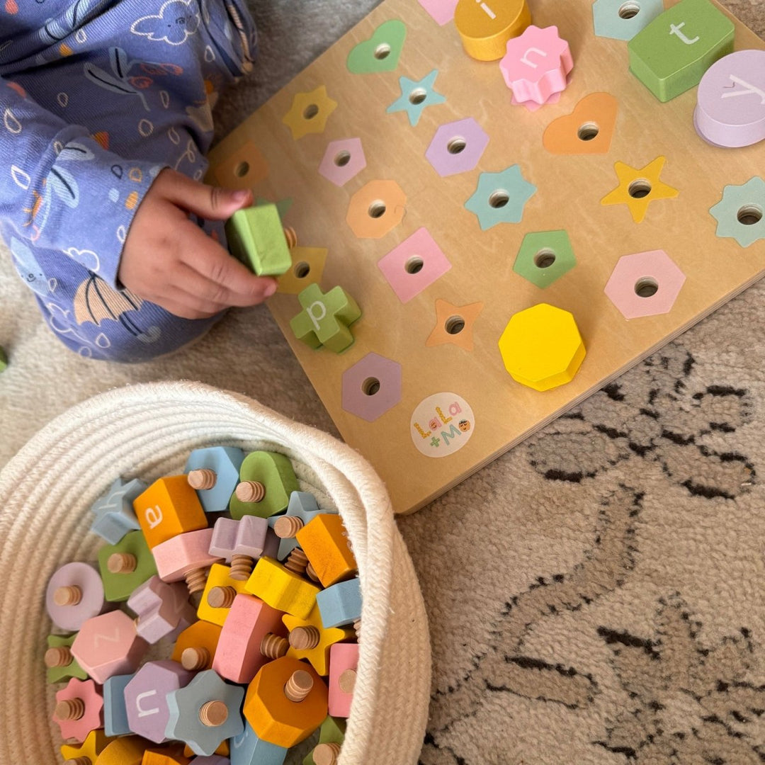 Child playing with colorful wooden letters on a mat and in a basket.