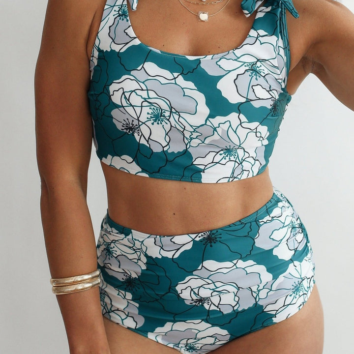 Teal and white floral bikini set on a plain background