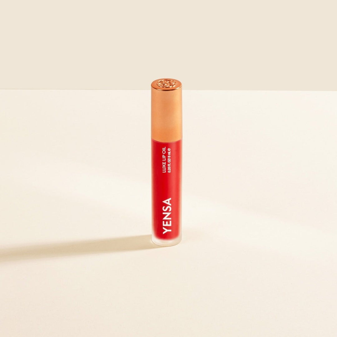 A single tube of YENSA Limoneta Lip Balm standing upright on a clean, warm off-white surface with a soft shadow cast to the left.
