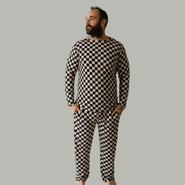 Man wearing a black and white checkered outfit against a plain background