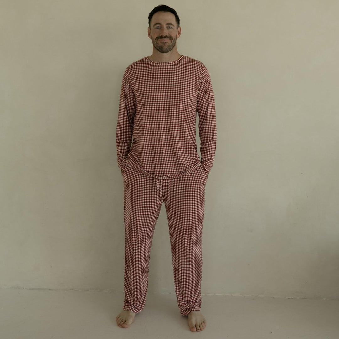 Man wearing a red checkered pajama set against a beige background