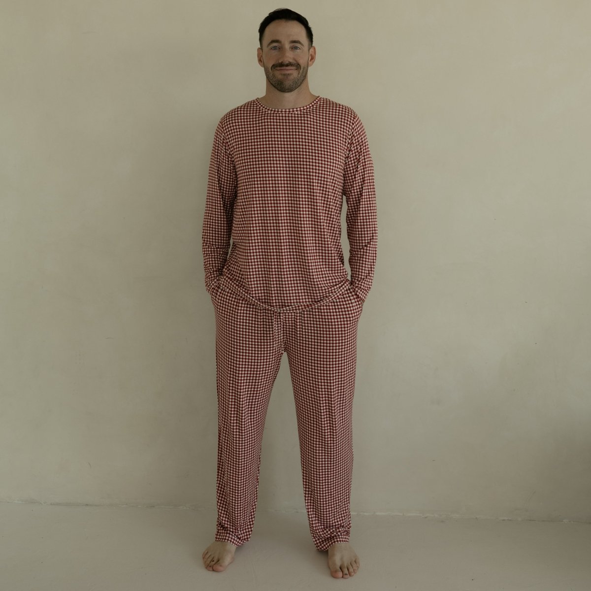 Man wearing a red checkered pajama set against a beige background