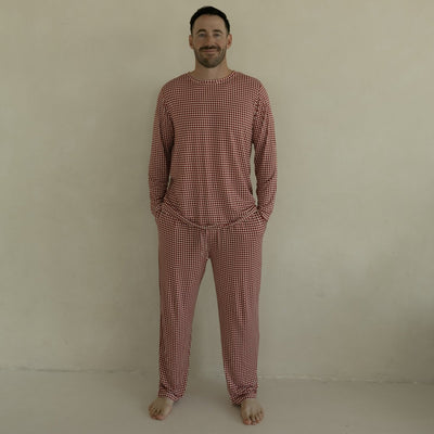 Man wearing a red checkered pajama set against a beige background