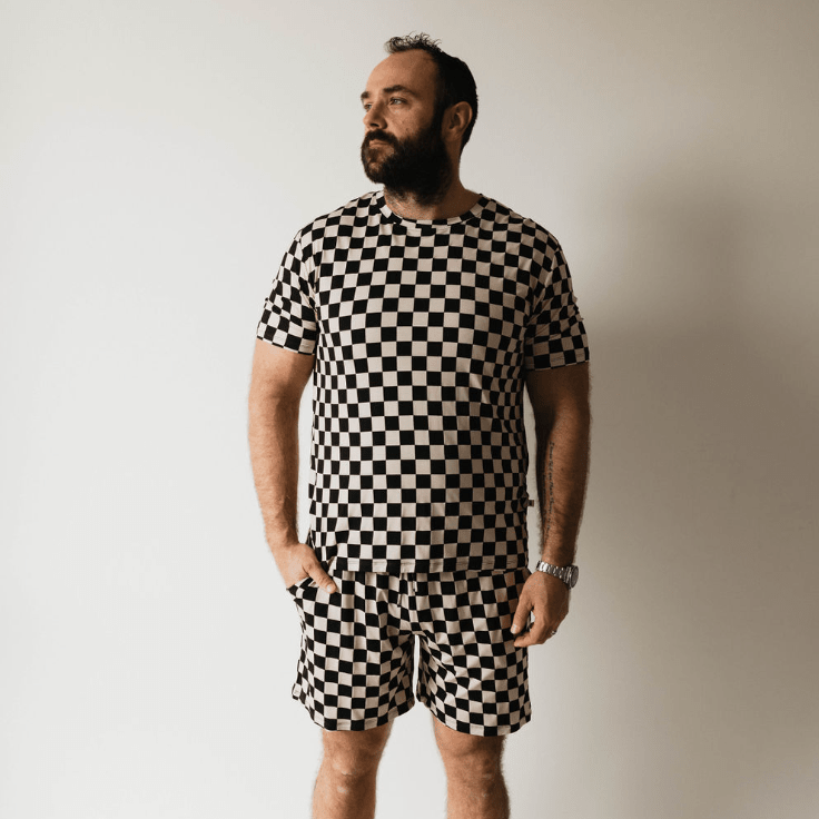 Man wearing a black and white checkered outfit against a plain background