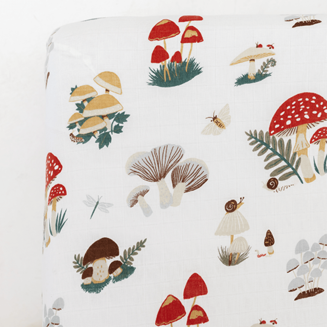Patterned fabric with mushrooms and foliage on a white background