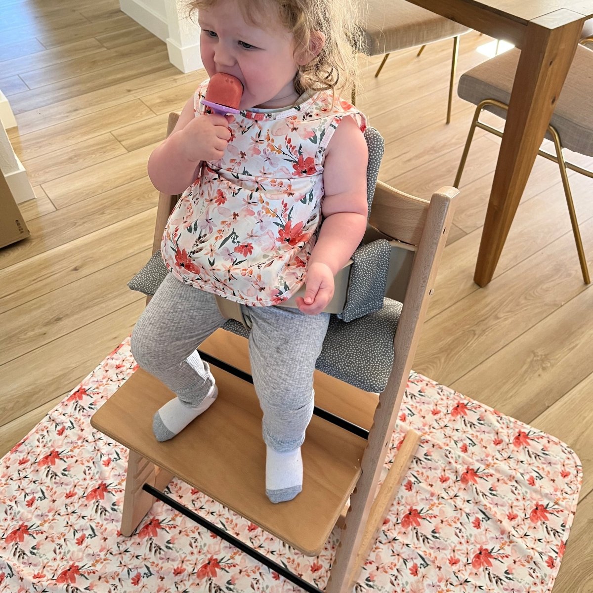 Child standing on a wooden step stool in a home setting