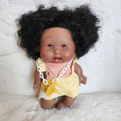 Baby doll with curly hair wearing a yellow outfit 