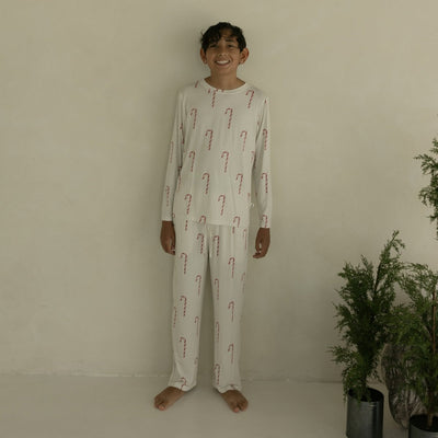 Person wearing a pajama set with candy cane pattern in a minimal indoor setting