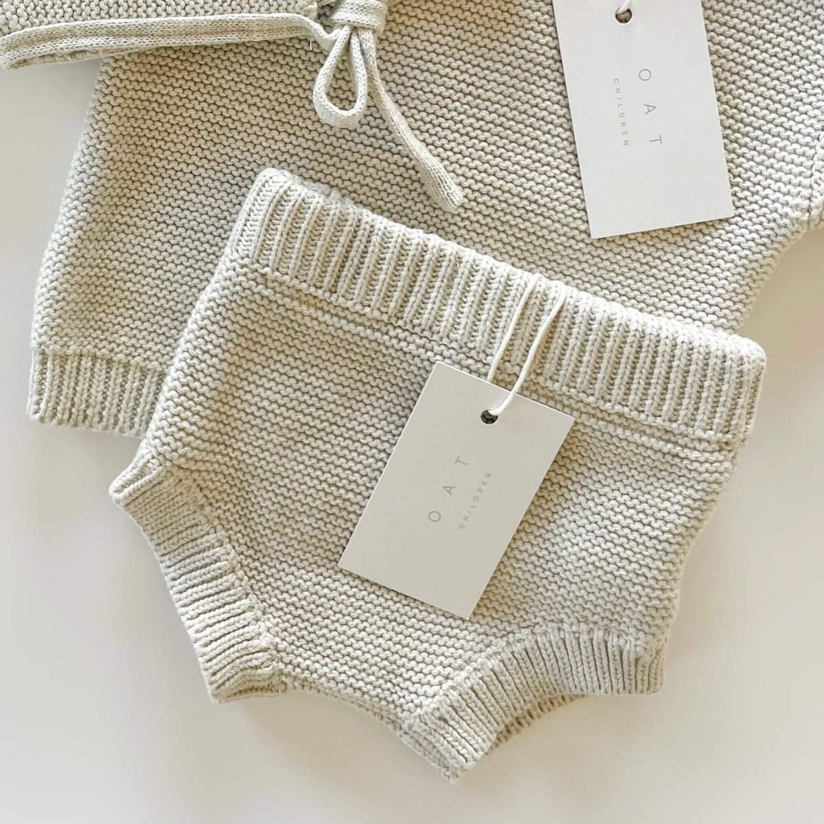 Knitted baby outfit with a top and shorts on a white background