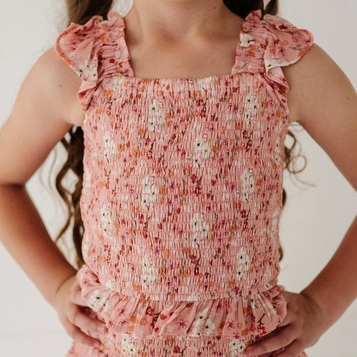 Child wearing a pink floral dress with a plain background