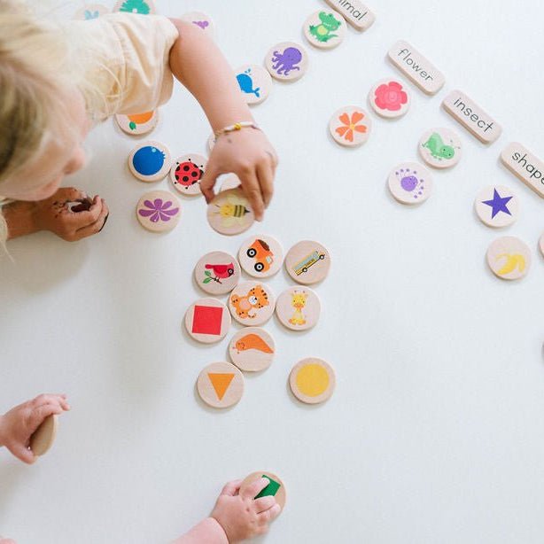 Children playing with educational wooden toys on a white surface