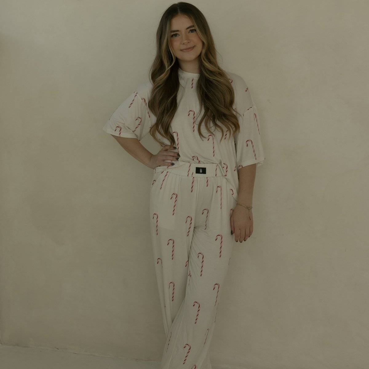 Woman wearing a white outfit with red patterns against a beige background