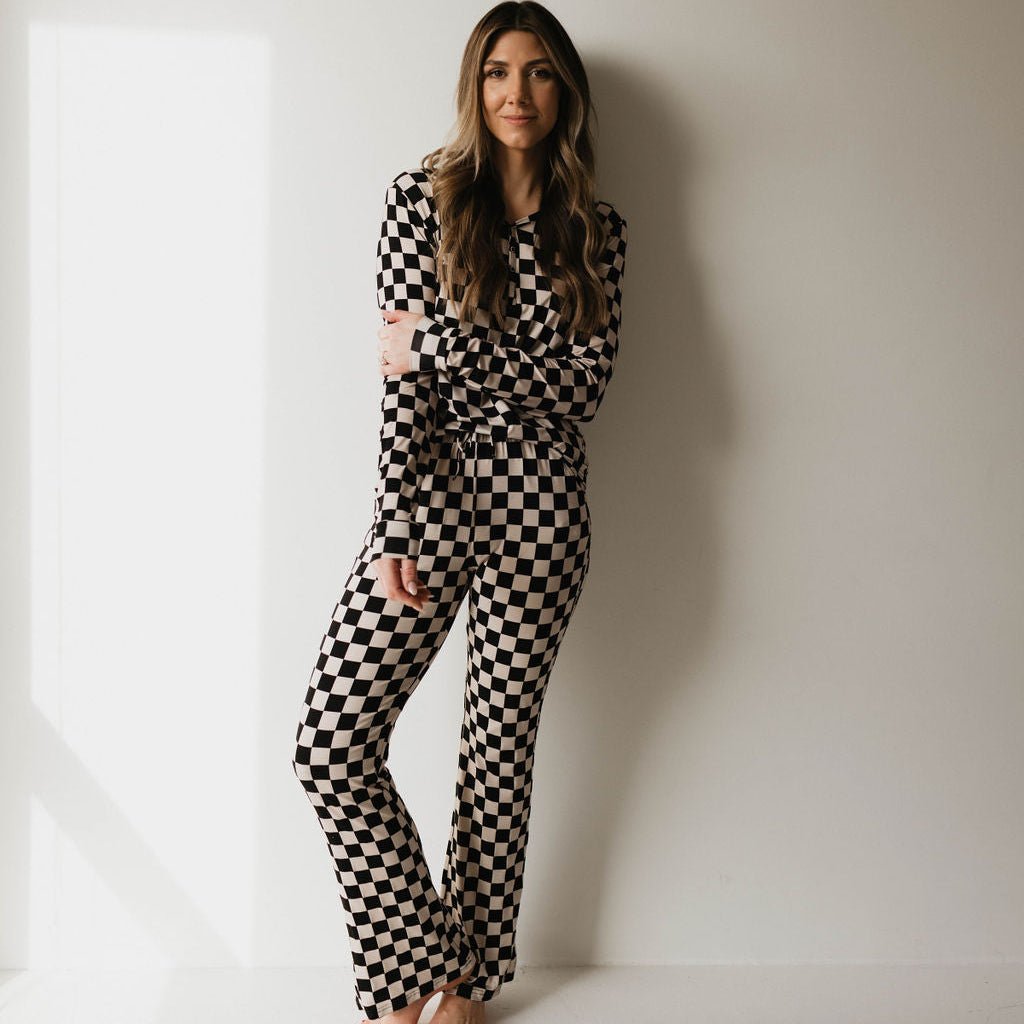 Woman wearing a black and white checkered outfit against a plain background